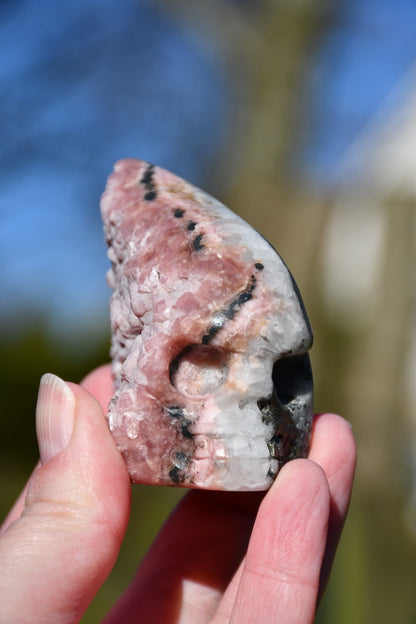 Rhodochrosite, pyrite and quartz skull - Manus carve