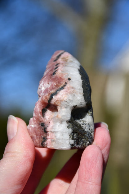 Rhodochrosite, pyrite and quartz skull - Manus carve